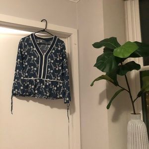Denim blouse with floral detail.